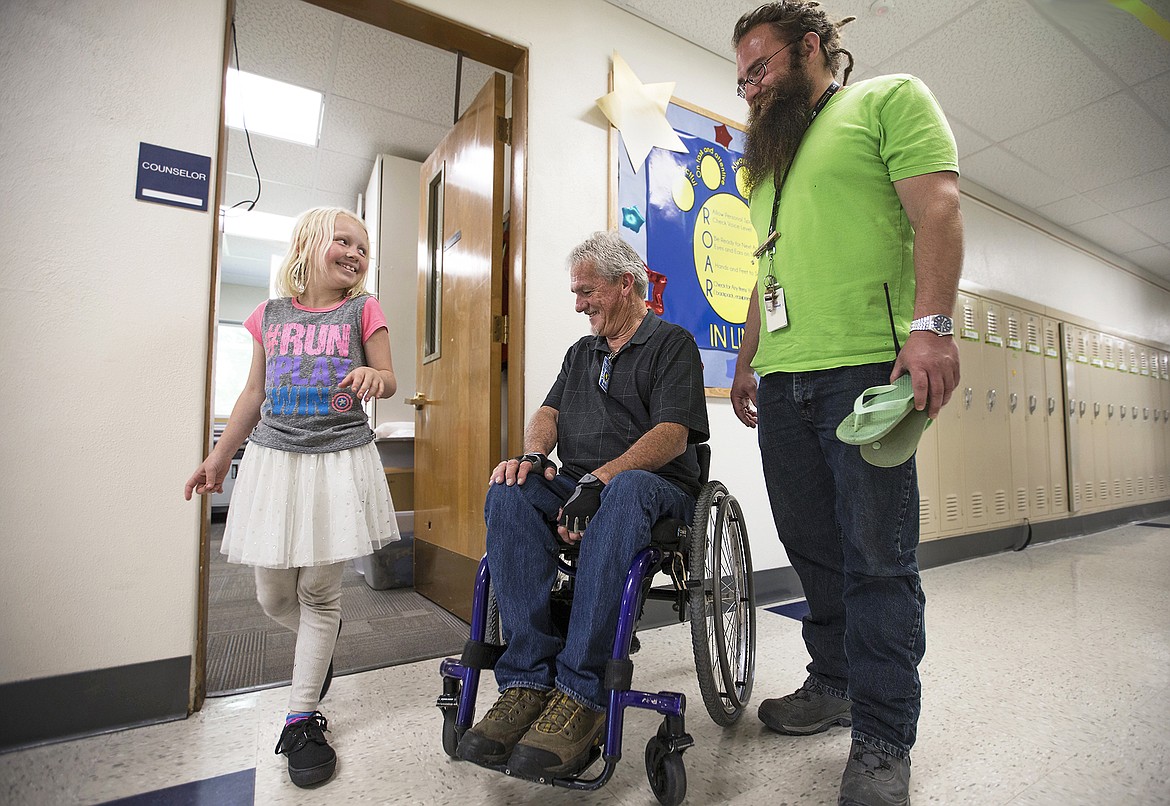 LISA JAMES/Press  

Borah Elementary School third-grader Chloe Murphy takes a walk in her new shoes as volunteer Wayne Juneau, center, and counselor Adam Foote look on. Juneau, who lost the use of his legs in a dirt bike accident when he was 21, recently had a dream of putting on new shoes and running again. The dream has motivated him to put his volunteering efforts towards  providing children at Borah Elementary School with new shoes. 
Juneau's GoFundMe Page, Soles for Kids, has helped get the program going, but he says he still has trouble getting shoes in enough variety of sizes.