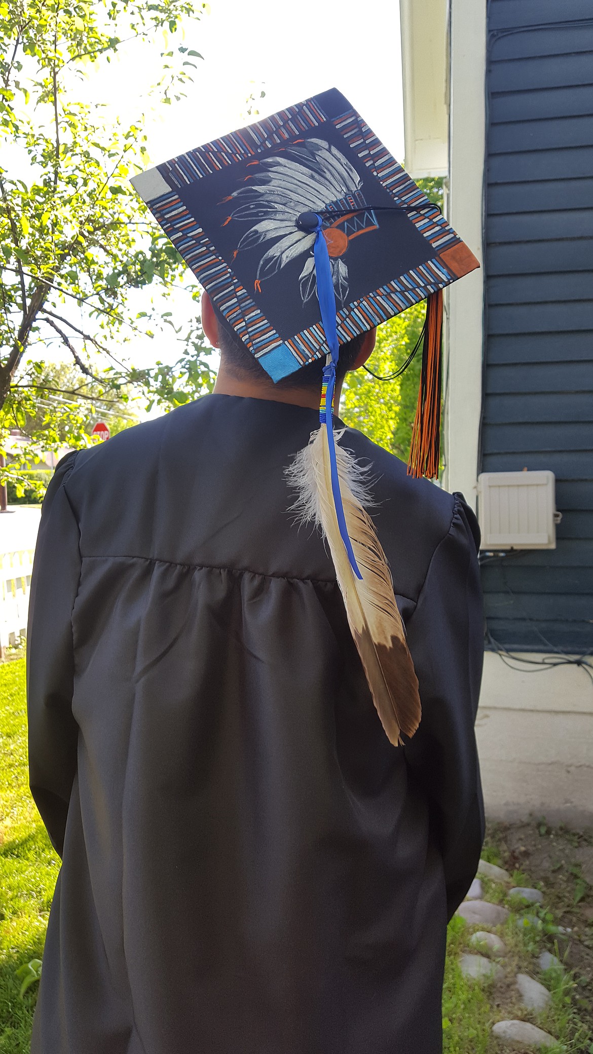 Flathead High School graduate Zephrey Holloway, 17, poses with a graduation cap painted by his grandmother and an eagle feather to signify his Blackfeet heritage prior to the commencement ceremony on June 2. Holloway was not allowed to wear the cap as per school dress code for graduation, but Flathead has since apologized for the incident. (Photo courtesy of Muriel Winnier)