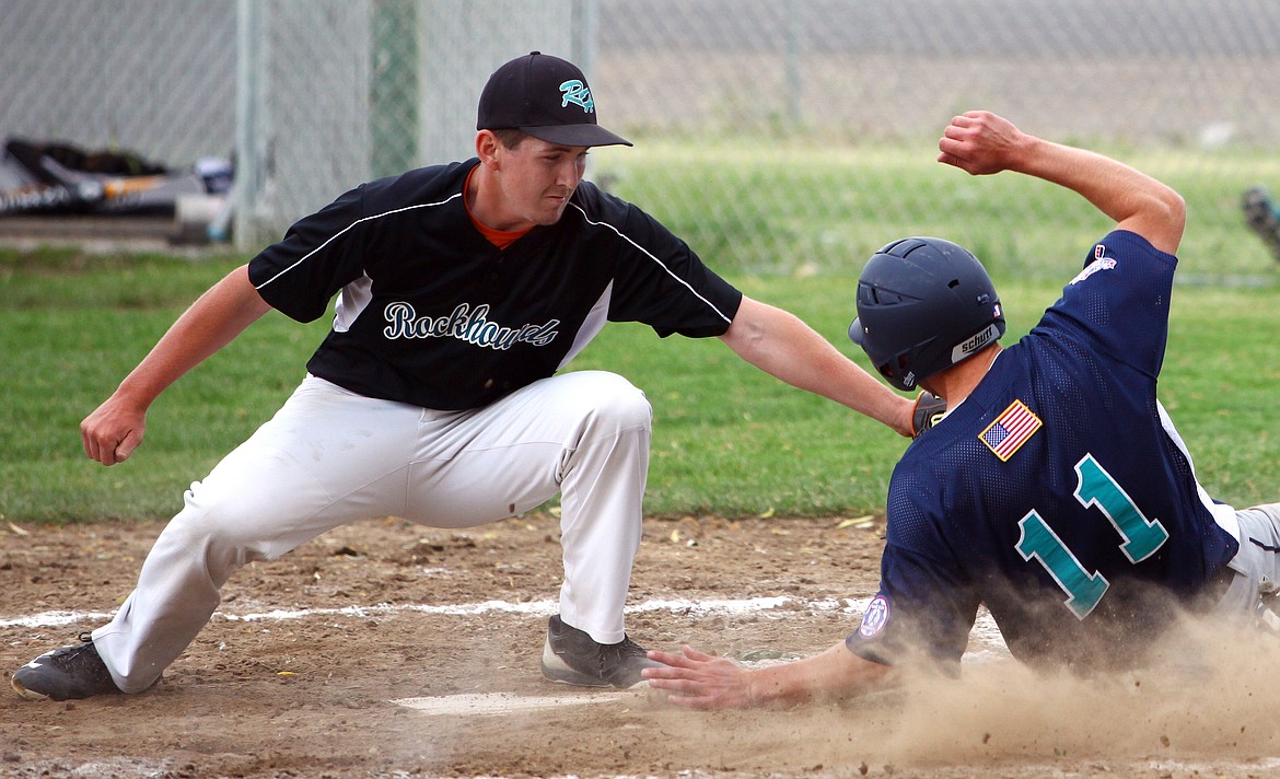 Rodney Harwood/Columbia Basin HeraldColumbia Basin River Dogs runner Joey Mihelich (11) beats the throw to the plate as Rockhounds pitcher Steven Louie makes the tag during Senior Babe Ruth action Thursday night in Ephrata.