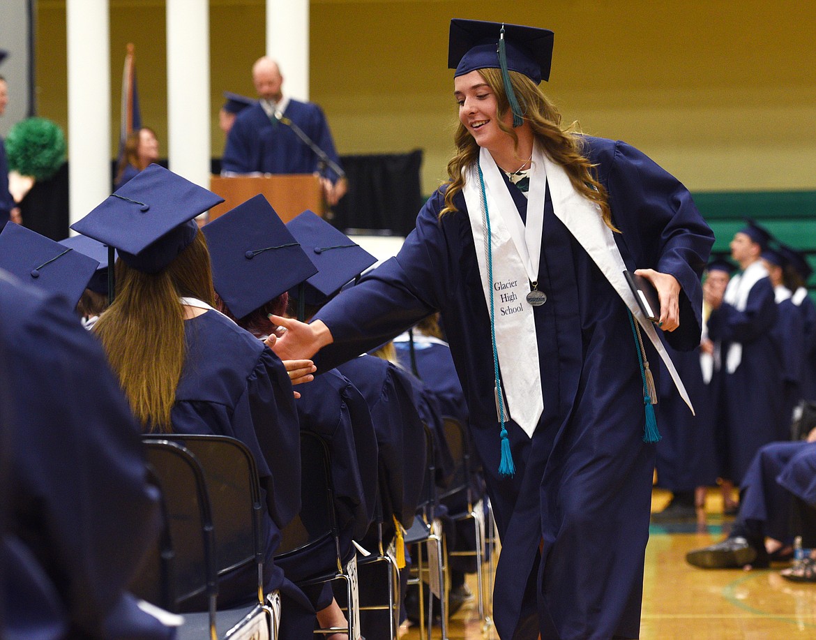 Glacier graduate Ahna Kreitinger gives a classmate a high-five after receiving her diploma at the Class of 2017 Commencement Ceremony at the high school on Saturday. (Aaric Bryan/Daily Inter Lake)