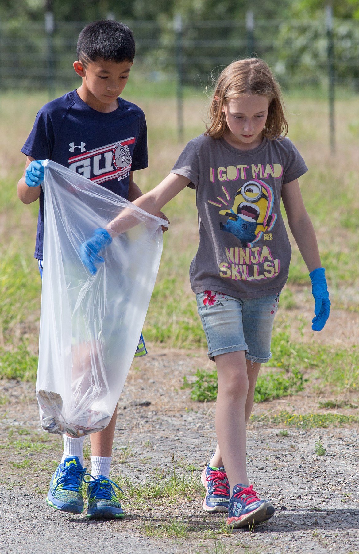 Libby Elementary School fifth-graders Gabe Gier and Annika Benner pick up trash along Treasure Avenue next to Libby Cemetery Wednesday, June 7, 2017. (John Blodgett/The Western News)