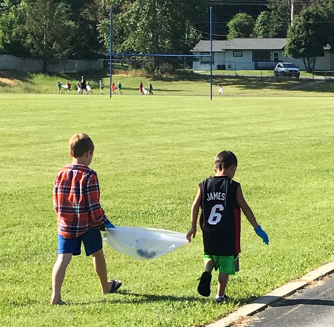 Libby kindergartners Zane White, left, and Brett Jury participate in a schoolwide community cleanup effort Wednesday, June 7, 2017. (Courtesy Photo)