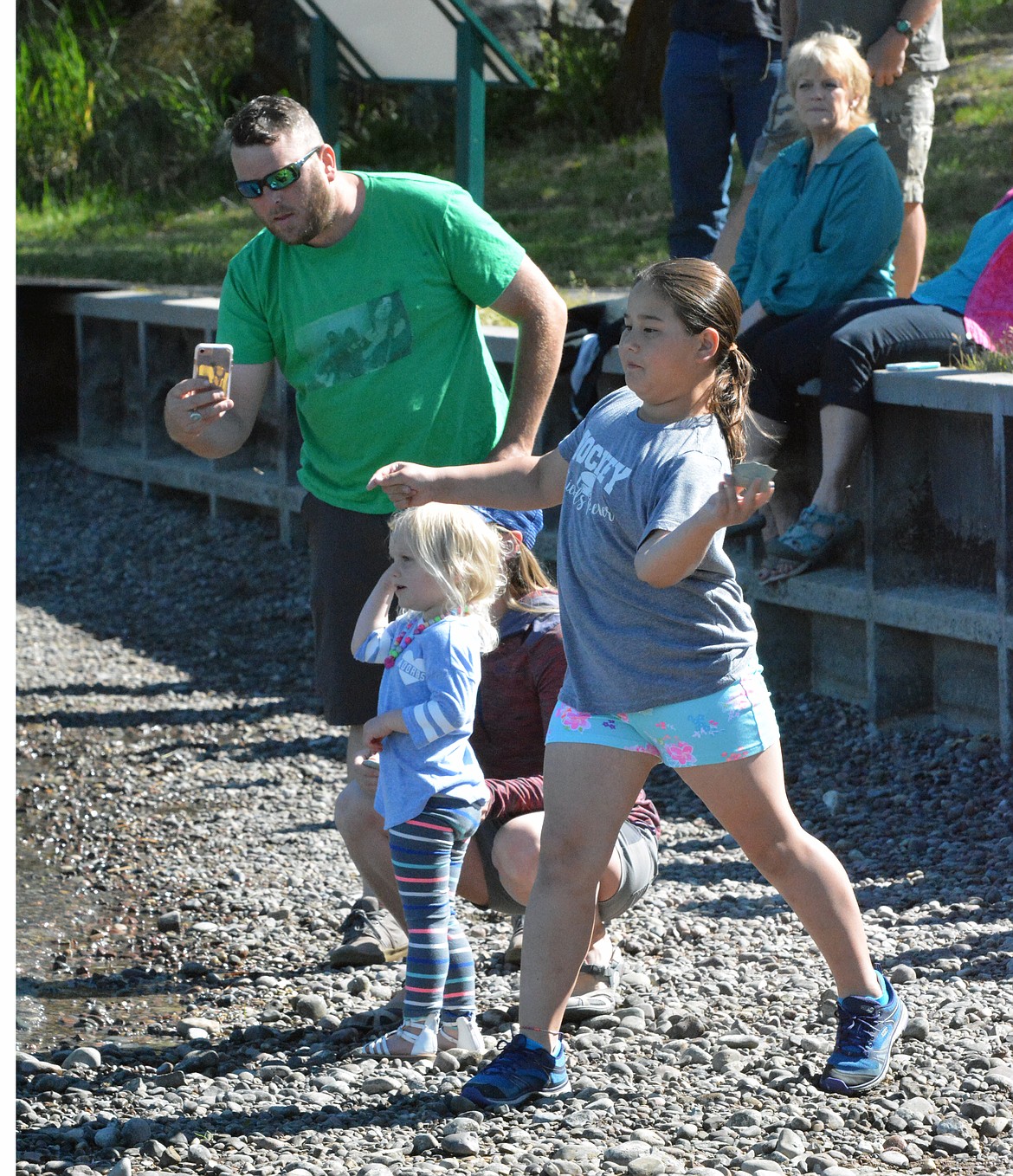 ROCK SKIPPING competitor Hilary Newman attempts to skip a rock along the Flathead Lake while the Kleinmeyers photographed her at the 3rd Annual Rock Skipping Competition Saturday at Riverside Park. (photo by Jason Blasco/Lake County Leader)