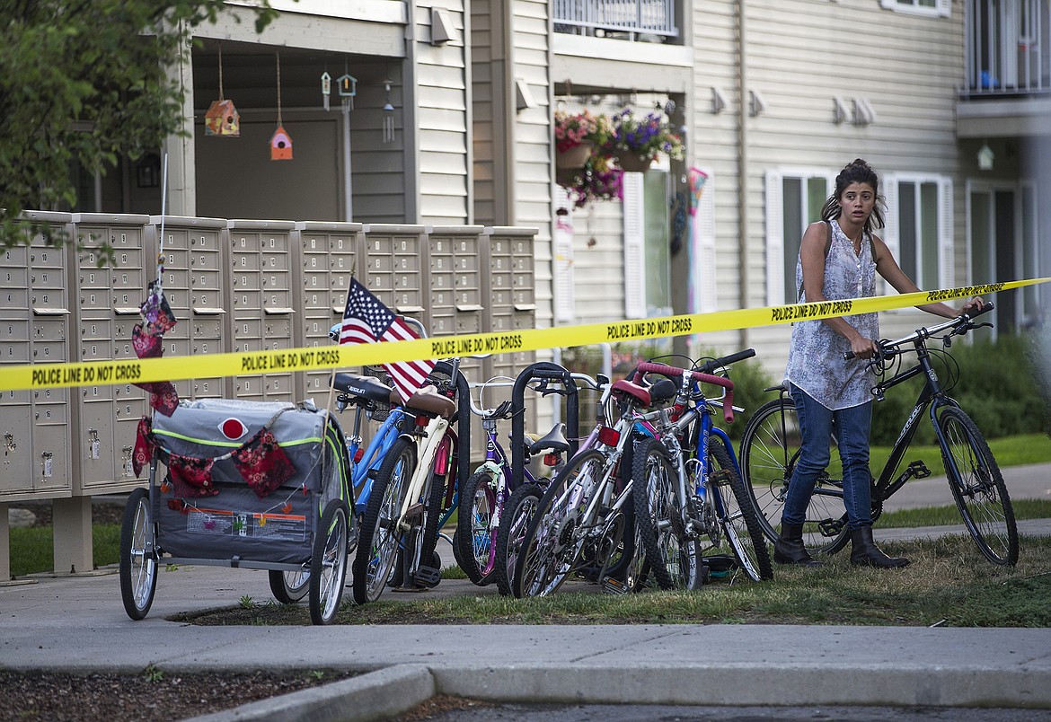 LISA JAMES/Press
A neighbor parks her bike behind police tape blocking off an area in the Falls Creek Apartments complex in Coeur d&#146;Alene where two bodies were found on Thursday.