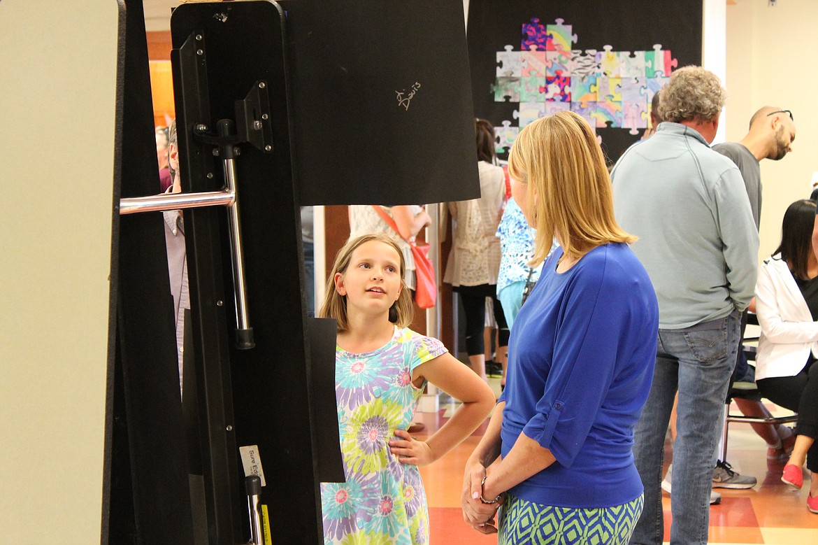 Charles H. Featherstone/Columbia Basin Herald
Fourth-grader Serena Murray talks art with Sage Point Elementary School principal Noreen Thomas during a student art exhibition Thursday.