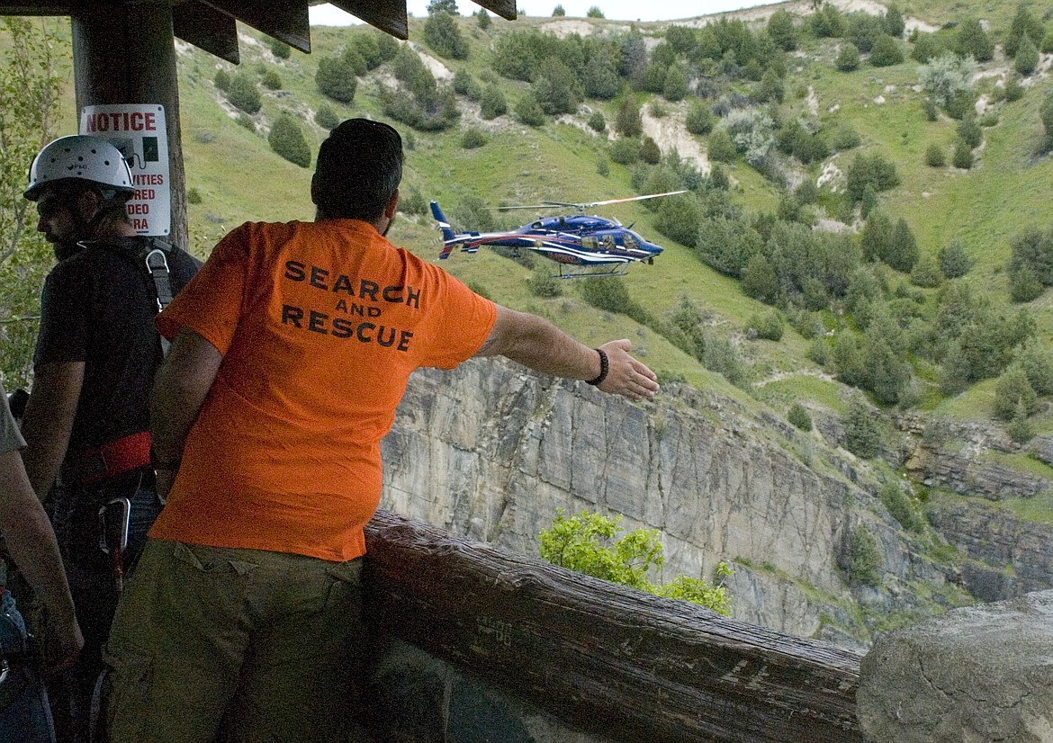 Lake County Search and Rescue President Jared Bell signals a helicopter from Two Bear Air during a search for a man who reportedly fell into the Flathead River below the Selis Ksanka Qlispe Dam Overlook Wednesday afternoon. (Brett Berntsen/Lake County Leader)