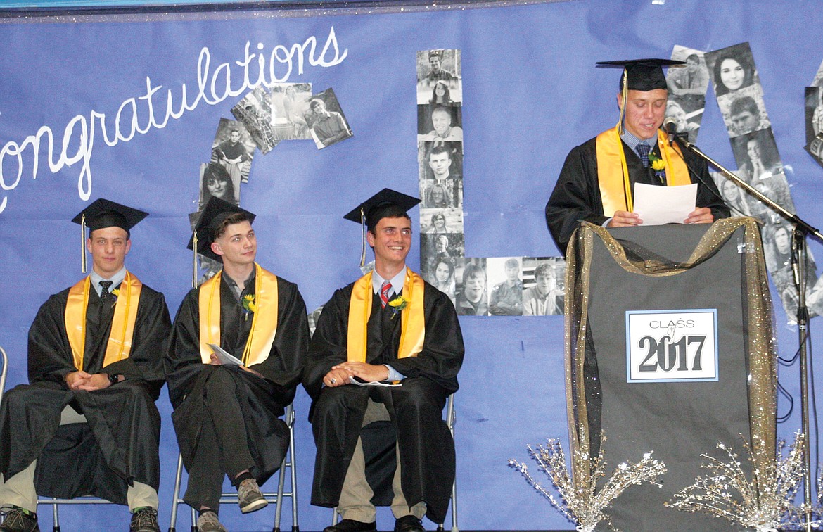 Co-valedictorian Colin Maloney, seated far left, listens to his fellow valedictorian Niklaus Gier speak along with salutatorian Bridger Herreid seated in center and Class of 2017 president Niklaus Neuman, seated on the right. (Elka Wood/The Western News)