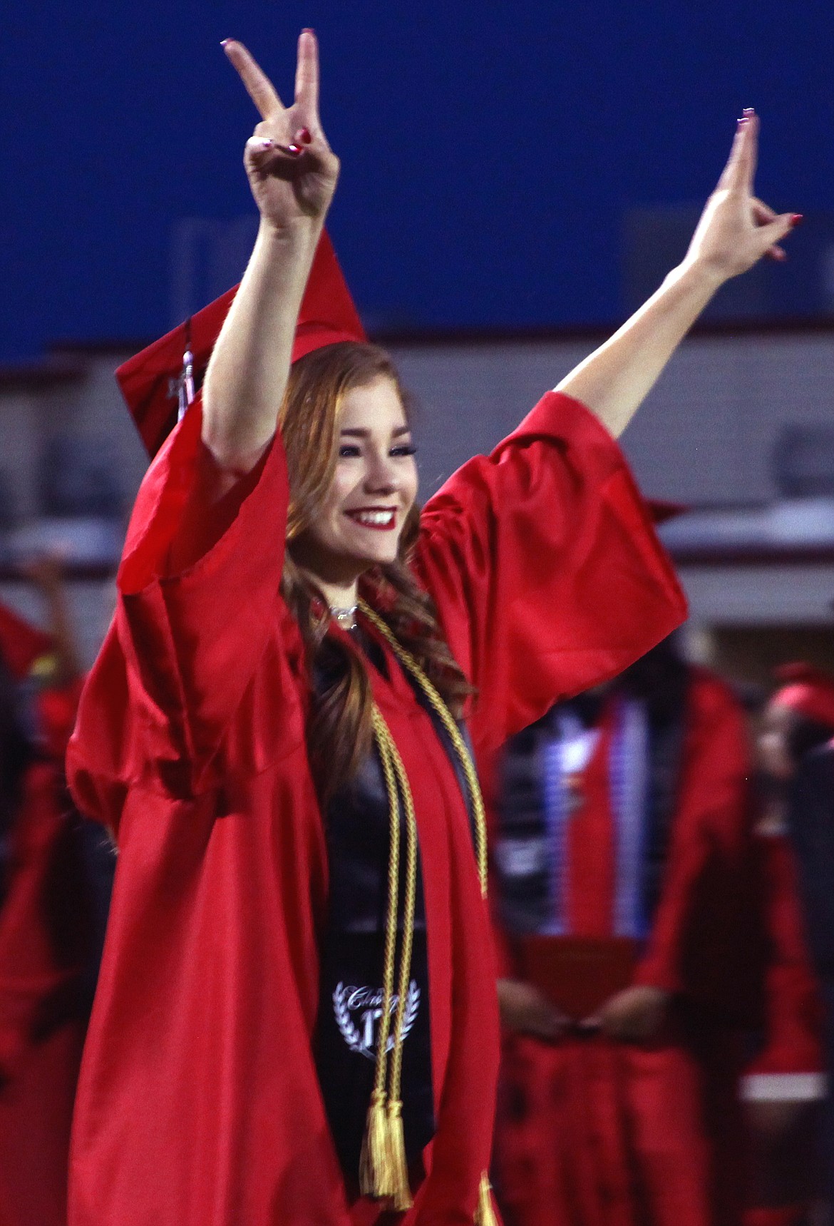 Rodney Harwood/Hagadone Newspaper Group - A 2017 Othello graduating senior reacts with peace signs after her name is called during the ceremonies June 2 at Husky Stadium.