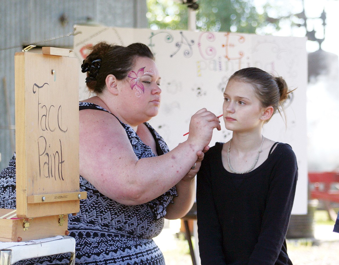 Tabitha Viergutz applies free face paint at Libby Museum&#146;s grand opening on Saturday.