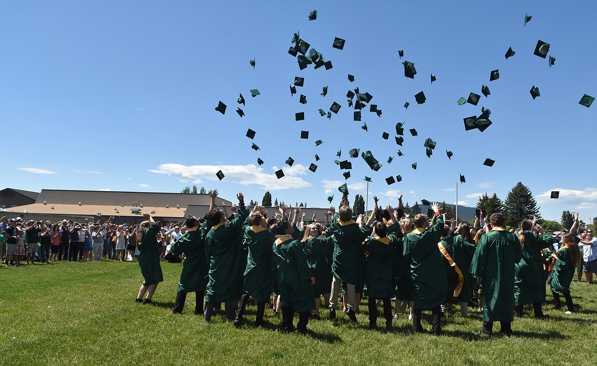 Members of the Whitefish High School class of 2017 toss their hats in the air June 3 outside the school following the commencement ceremony . (Heidi Desch/Whitefish Pilot)