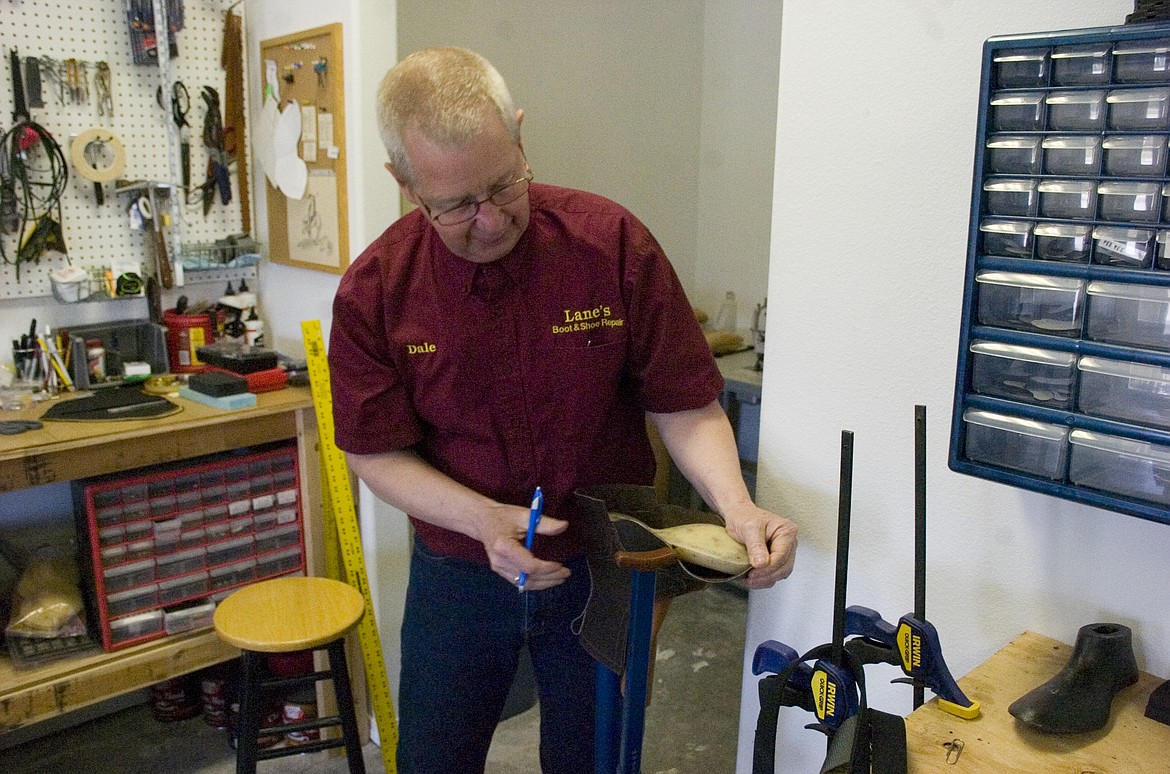 DALE LANE molds leather around a rigid form at his new boot and shoe repair shop in Polson last week. (Brett Berntsen/Lake County Leader)