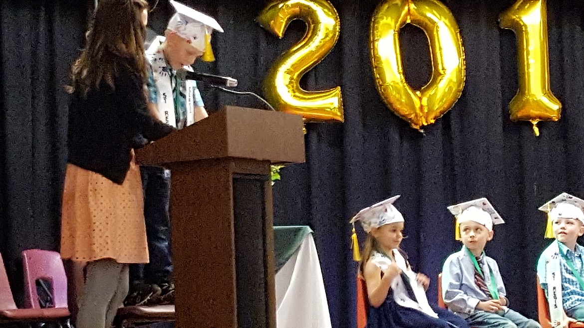 Kindergartener Chet Hill read a poem during graduation ceremonies with the help of teacher Mallery McElderly. (Photo courtesy of Joe Steele).