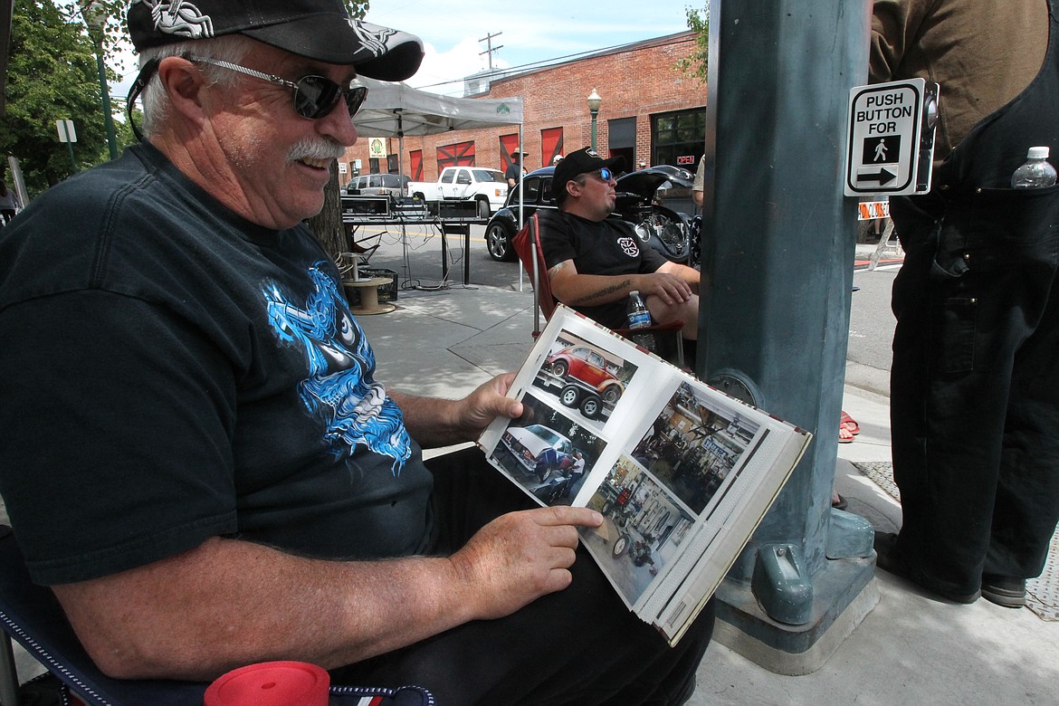 Kevin Massengale shares pictures of his Beetle rebuild projects while showing his custom '65 Beetle at Car d'Lane with his son-in-law Mike Tibbetts and grandson Logan on Saturday. Tibbetts also drives a Beetle that his father-in-law rebuilt. He and his black Bug can be seen in the background.