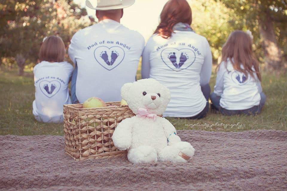 Courtesy photo
The Staples family wears &quot;Sister of an Angel,&quot; &quot;Dad of an Angel&quot; and &quot;Mom of an Angel&quot; shirts in this fall 2014 photo as they sit by the bear the hospital gave them when Charlotte was born. Charlotte was stillborn and would have been 4 on July 5.