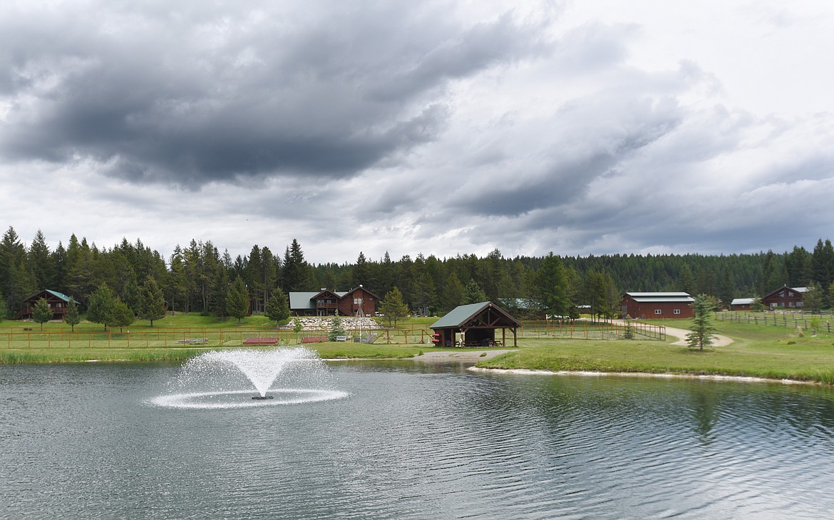 A large pond and fountain sits in front of the lodge and cabins at the Glacier Ridge Ranch. (Aaric Bryan/Daily Inter Lake)