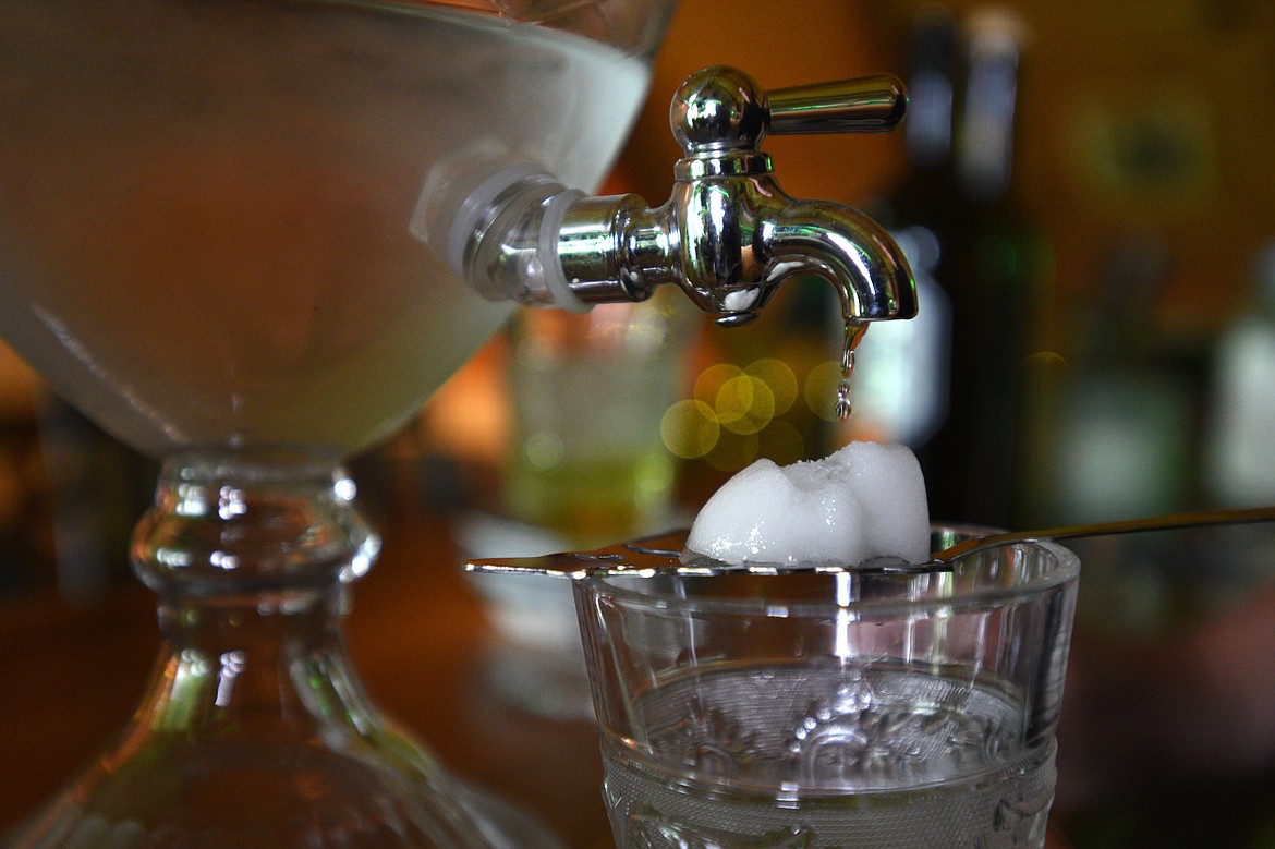 Ice water drips on a sugar cube above a glass of absinthe before being served &#151; a process called &#147;La Louche.&#148; When the water combines with the absinthe it makes a milky blend.