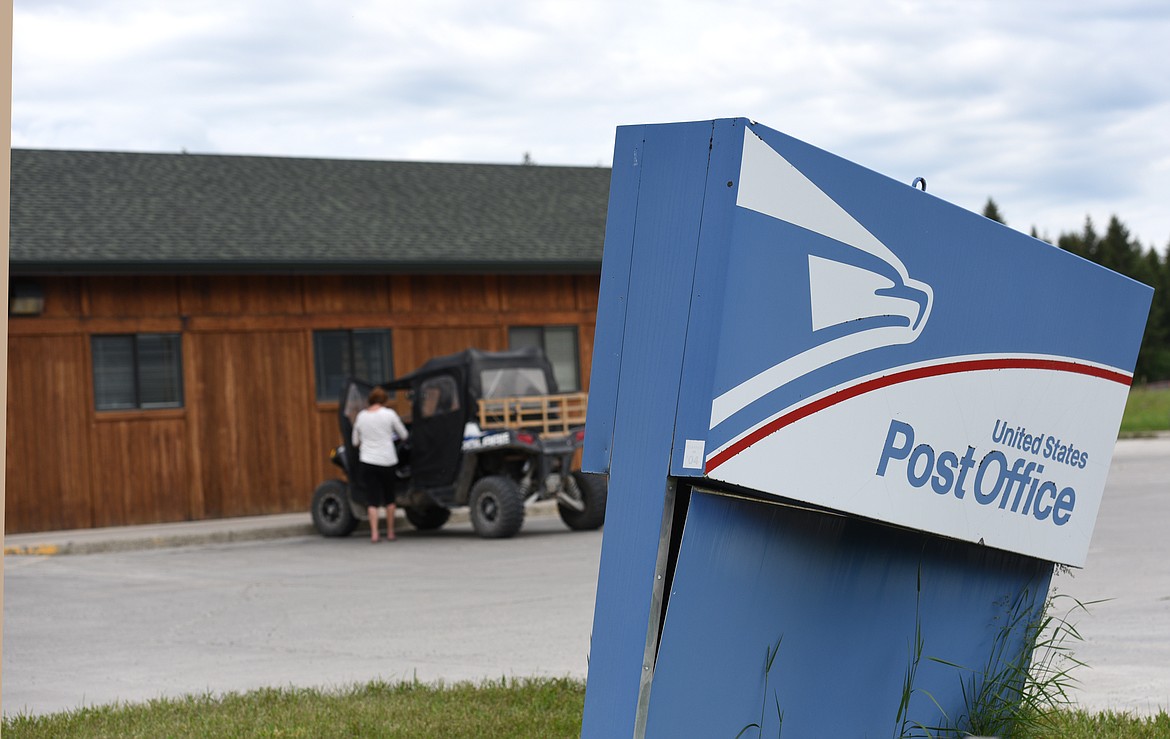 A woman gets in her vehicle after leaving the United States Post Office in Trego on Tuesday. (Aaric Bryan/Daily Inter Lake)