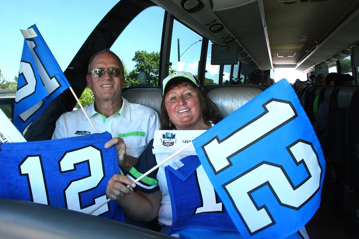 Rodney Harwood/Columbia Basin Herald - Roger and Sharon Ensz display their colors, sitting in the front seat of the Seahawks 12 Tour bus as it prepares to head to Lions Park on Sunday.