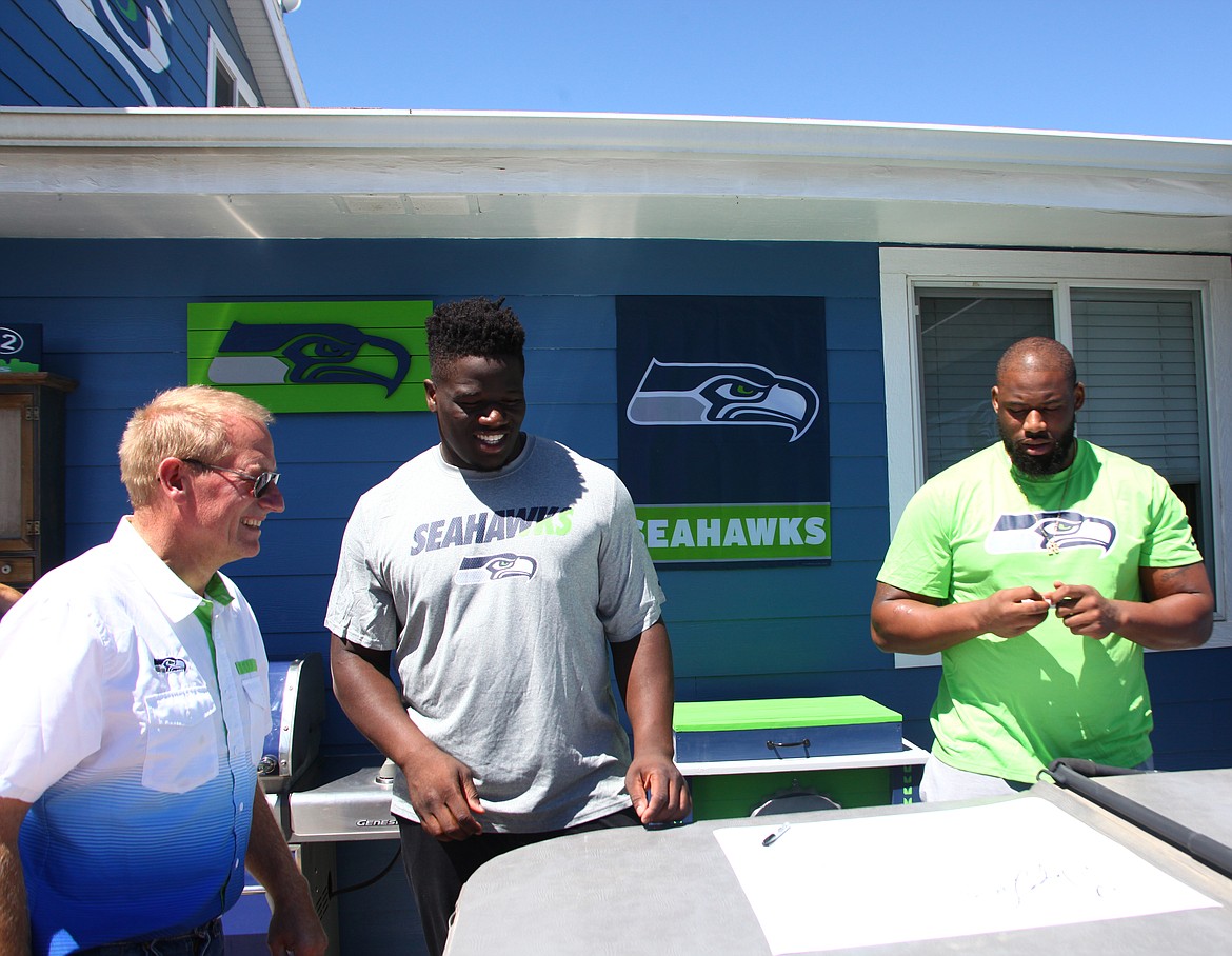 Rodney Harwood/Columbia Basin Herald - Roger Ensz of Othello, left, talks with Seahawks offensive linemen Germain Ifedi, center and George Fant during the 12 Tour stop at his Seahawks House Sunday morning.