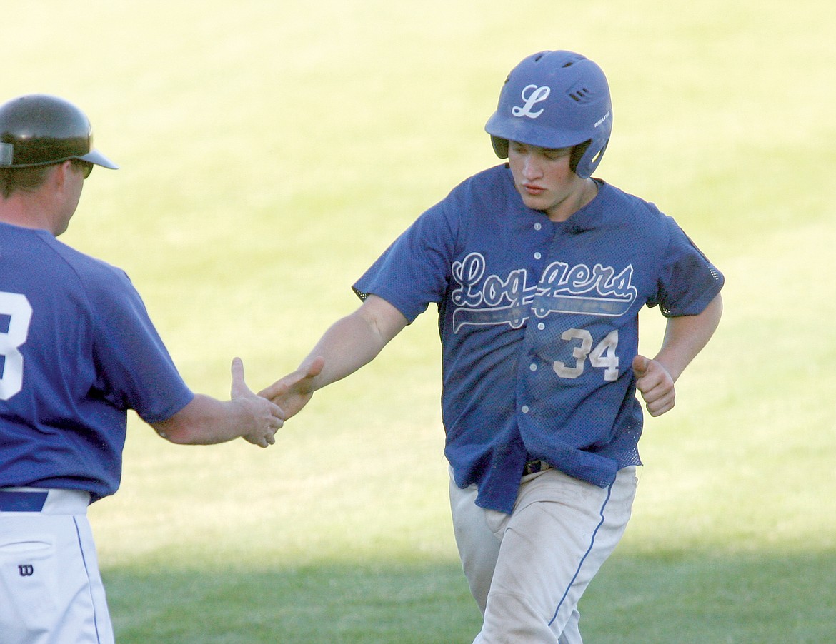 Brady Bateman gets a congratulatory handshake from manager Kelly Morford as he rounds third base after his solo homerun in the bottom of the third inning Monday evening. Loggers go on to win 14-6 in the second of a doubleheader vs. the Mariners. (Paul Sievers/The Western News)