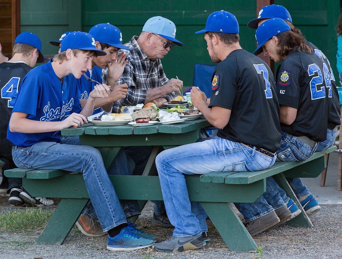 Libby Logger Legion ball players take a break from serving others to eat during Dinner on the Diamond at Lee Gehring Field in Libby Friday, June 9, 2017.