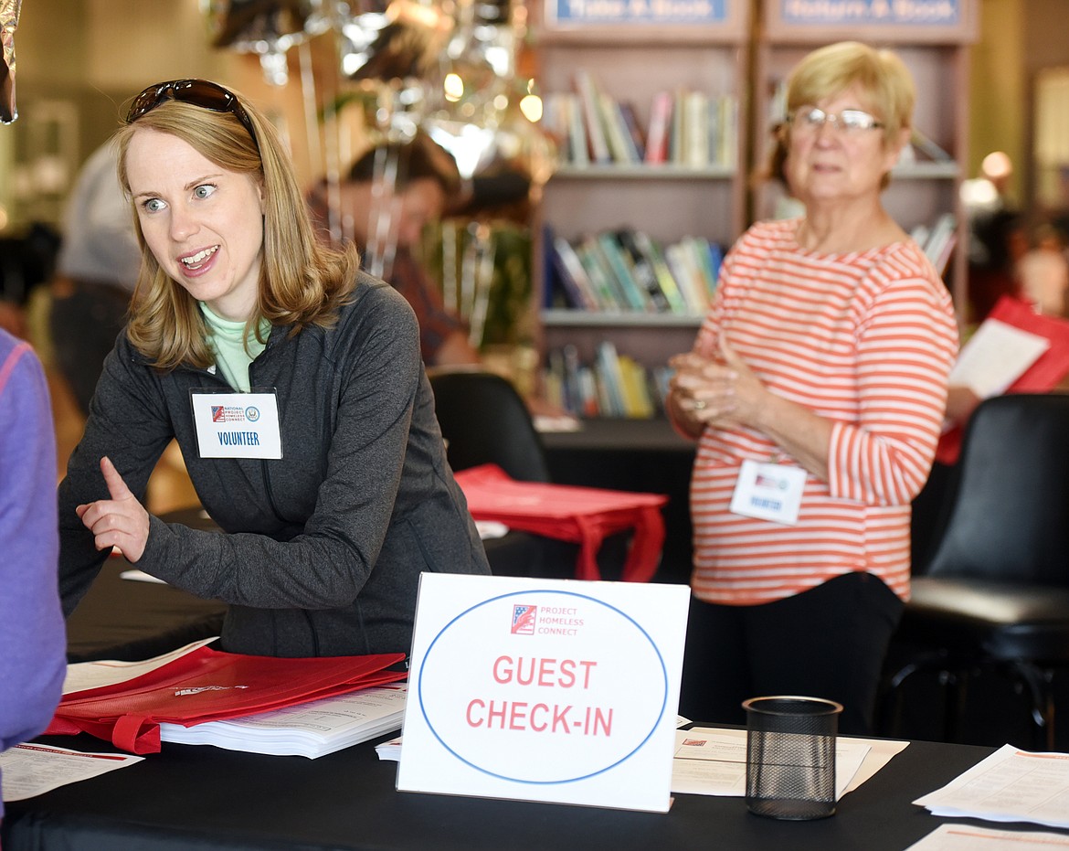 Jessica Tubbs, a volunteer for the United Way helps get people checked in to take part in Project Homeless Connect on Friday in Kalispell. In the background is volunteer Toni Gunnerson.