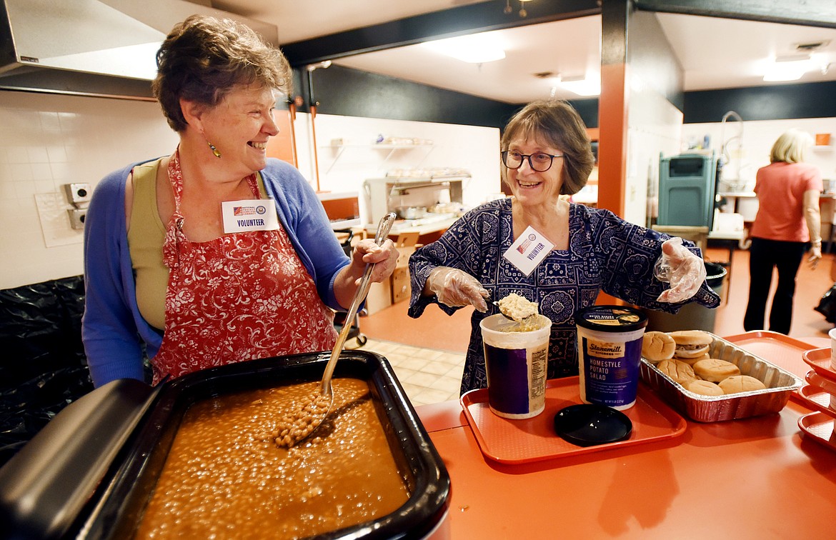 Hollie Widdekind and Lanni Fetveit volunteer for the United Way by serving lunch at Project Homeless Connect on Friday in Kalispell. (Brenda Ahearn photos/Daily Inter Lake)