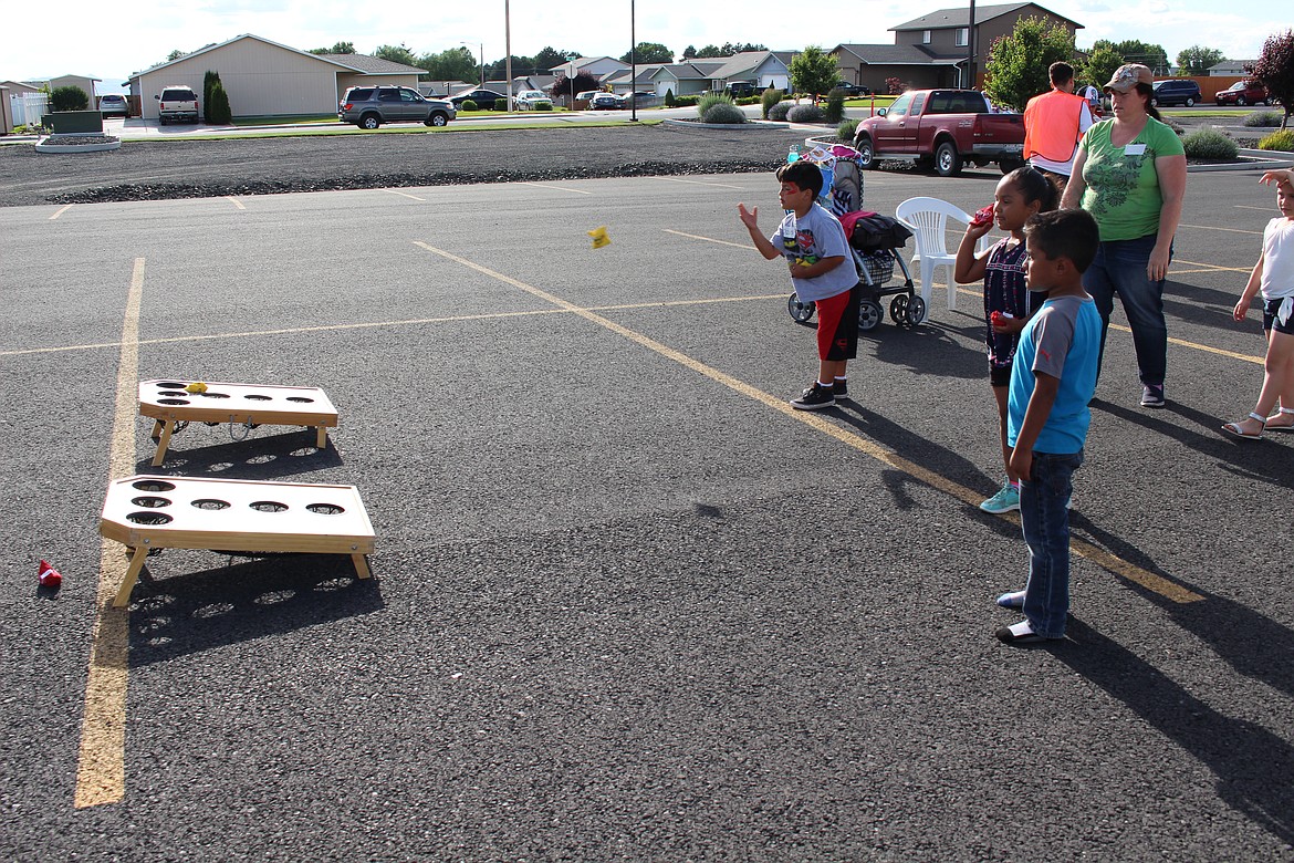 Chanet Stevenson/The Sun Tribune - A game of bean bag toss kept provided much entertainment for kids during the Othello Community BBQ Friday held at the Nazarene Church of Othello.