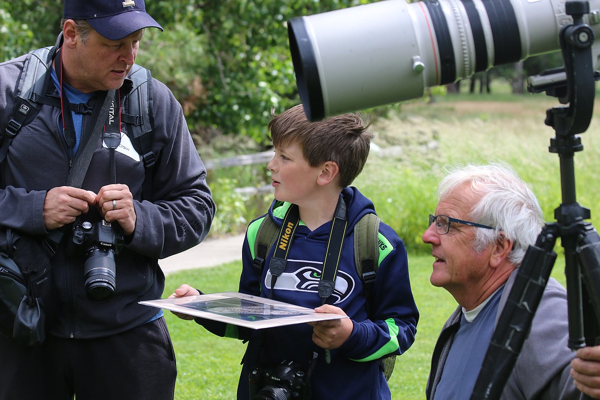 Photo by Mandi Bateman
David Brinkman, with his son Logan Brinkman, meet with photographer Steve Jamsa, who signs Logan&#146;s photo and gives the young photographer advice.