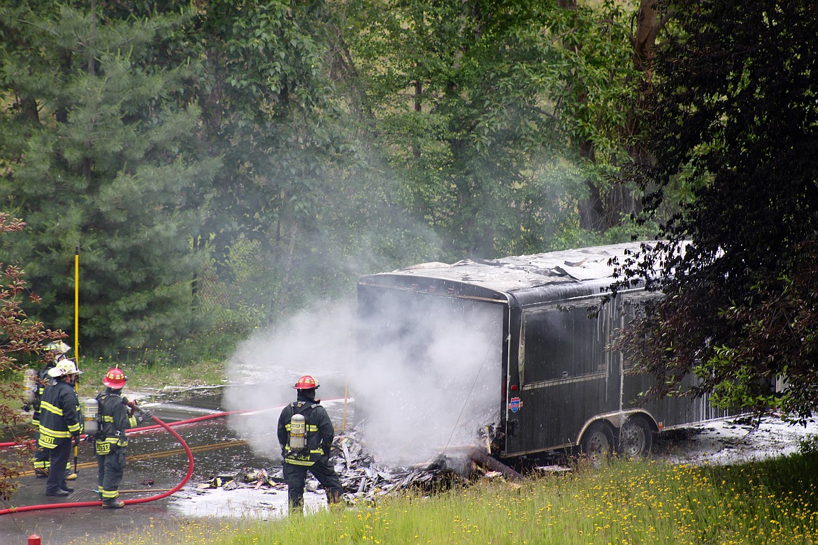 Smoke and water are pushed out as crews attack the trailer fire from both sides.