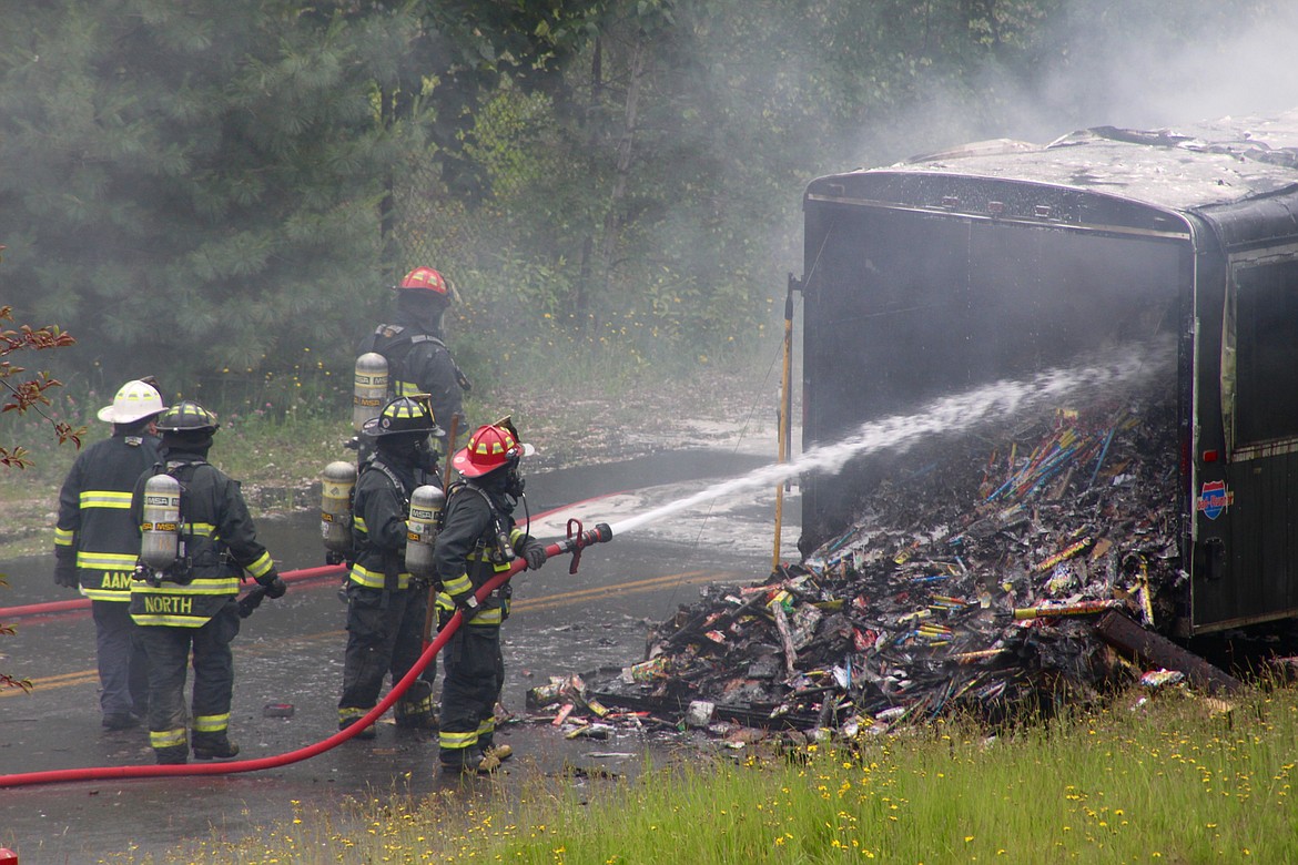 Firefighter Schaefer hoses down the trailer.