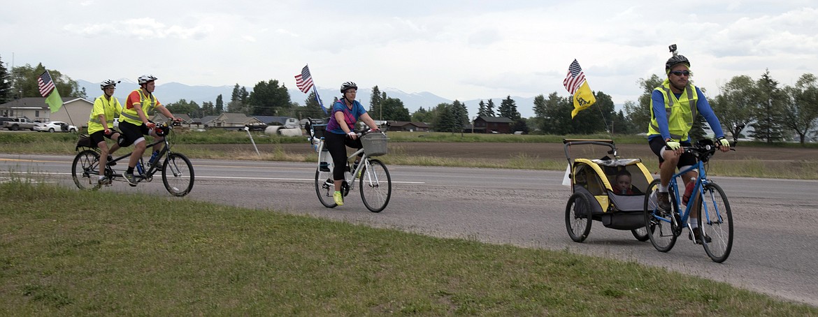 The Henretti family--Joe, Beth, Joshua, Devin, and Ethan (in trailer) while bking through Lake County. (Marla Hall/Clark Fork Valley Press)