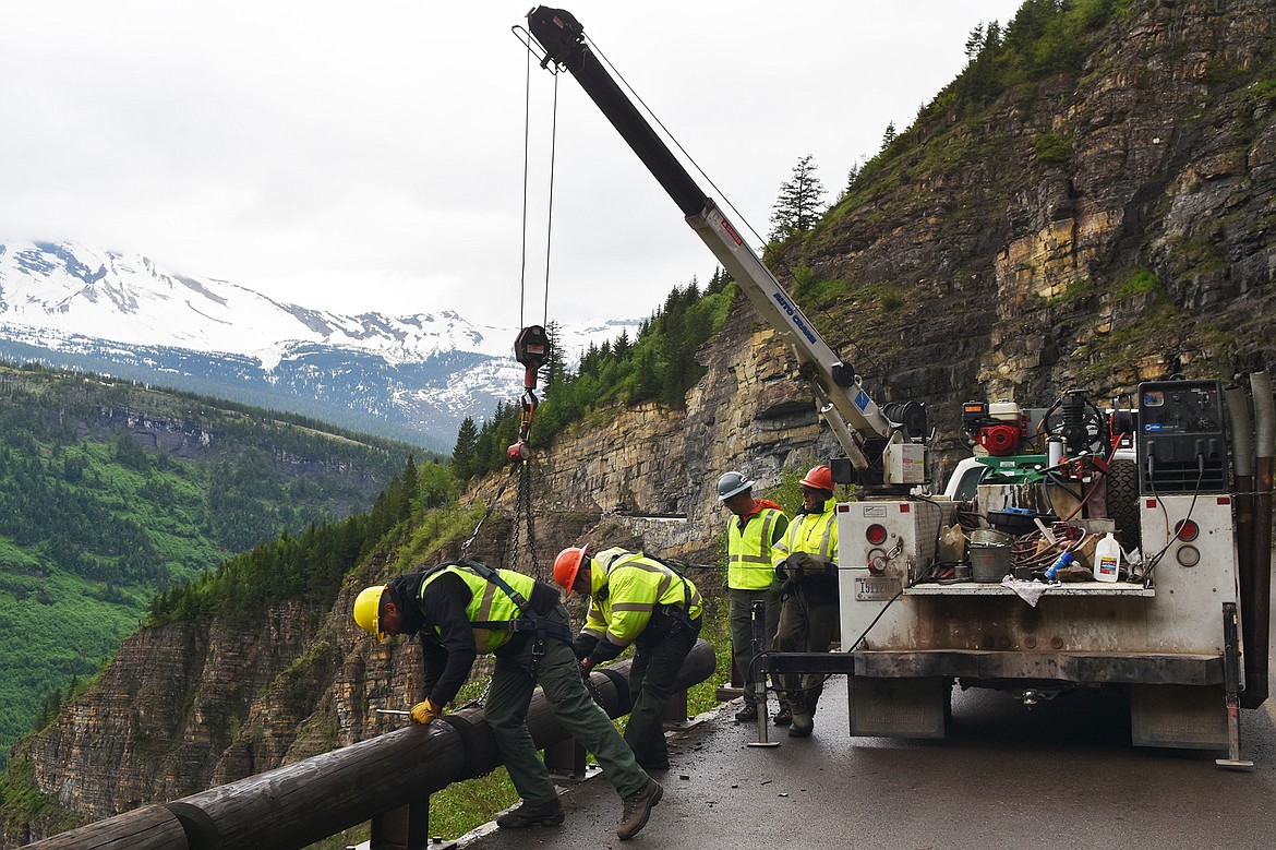 Crews install the railings on the Going-to-the-Sun Road Friday morning.