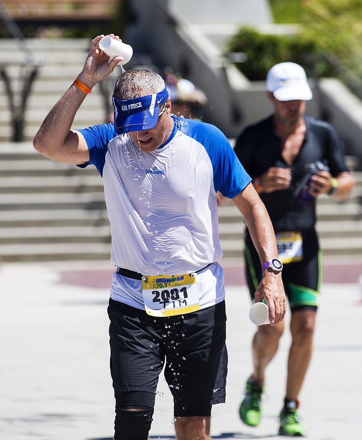 LOREN BENOIT/PressTim Burnside pours cold water on his head during the run portion of Ironman Coeur d'Alene 70.3.