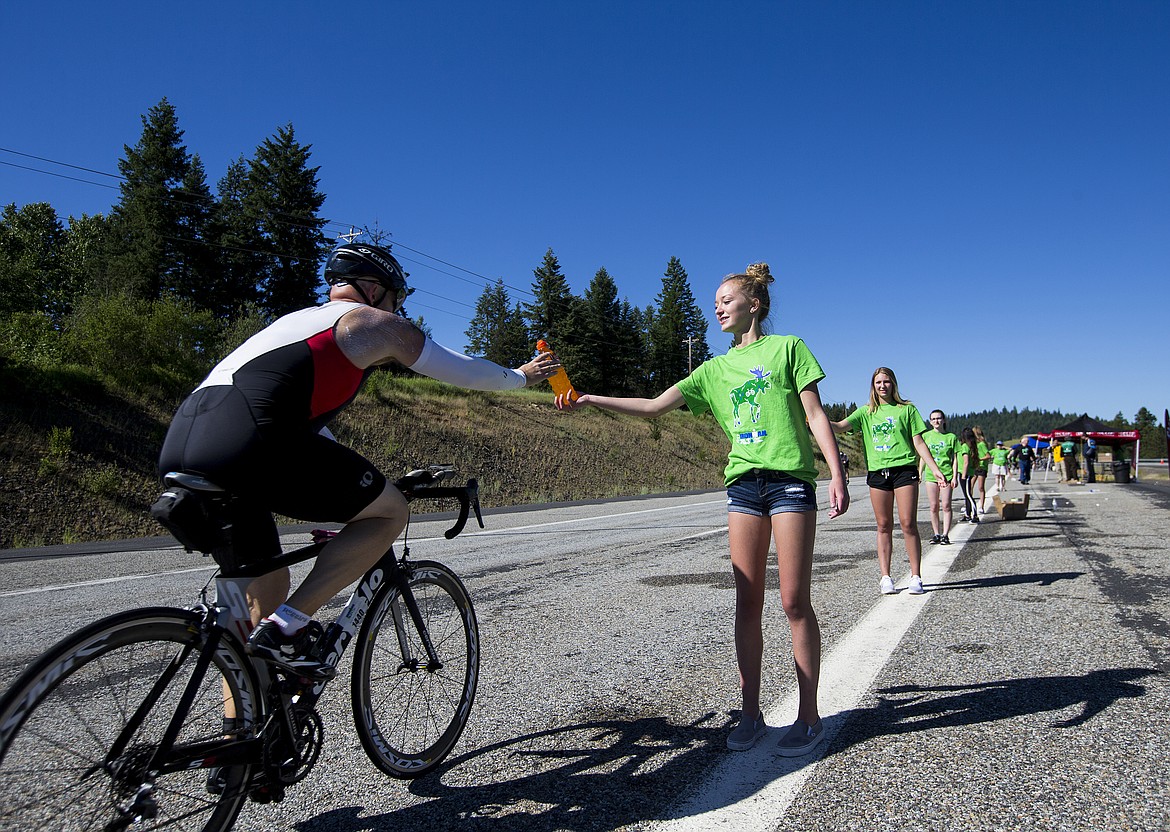 LOREN BENOIT/PressJaedyn Haggerty hands a gatorade to an Ironman athlete Sunday afternoon south of Coeur d'Alene. Dani Zibell-Wolfe, Ironman volunteer director, estimated that the event brought in more than 1,400 volunteers from throughout the region to lend a hand.