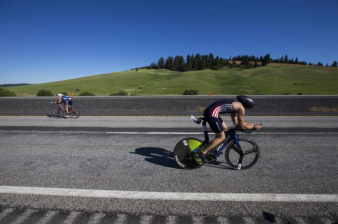 LOREN BENOIT/PressMathieu Signoretty, right, cycles north back to Coeur d'Alene during Ironman 70.3 on Sunday. Signoretty had a bike time of 2 hours, 33 minutes and 57 seconds. He finished 161th overall.