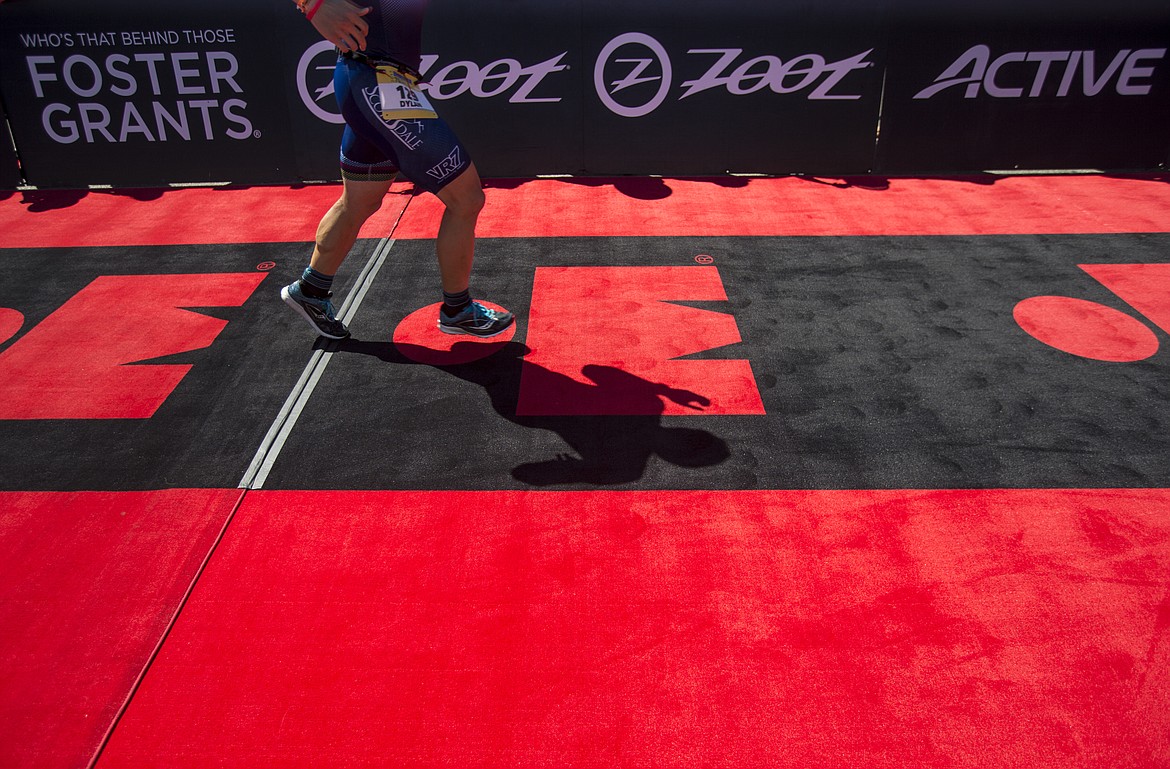 LOREN BENOIT/PressA shadow of an Ironman athlete is cast on the road carpet near the Ironman 70.3 Coeur d'Alene finish line.