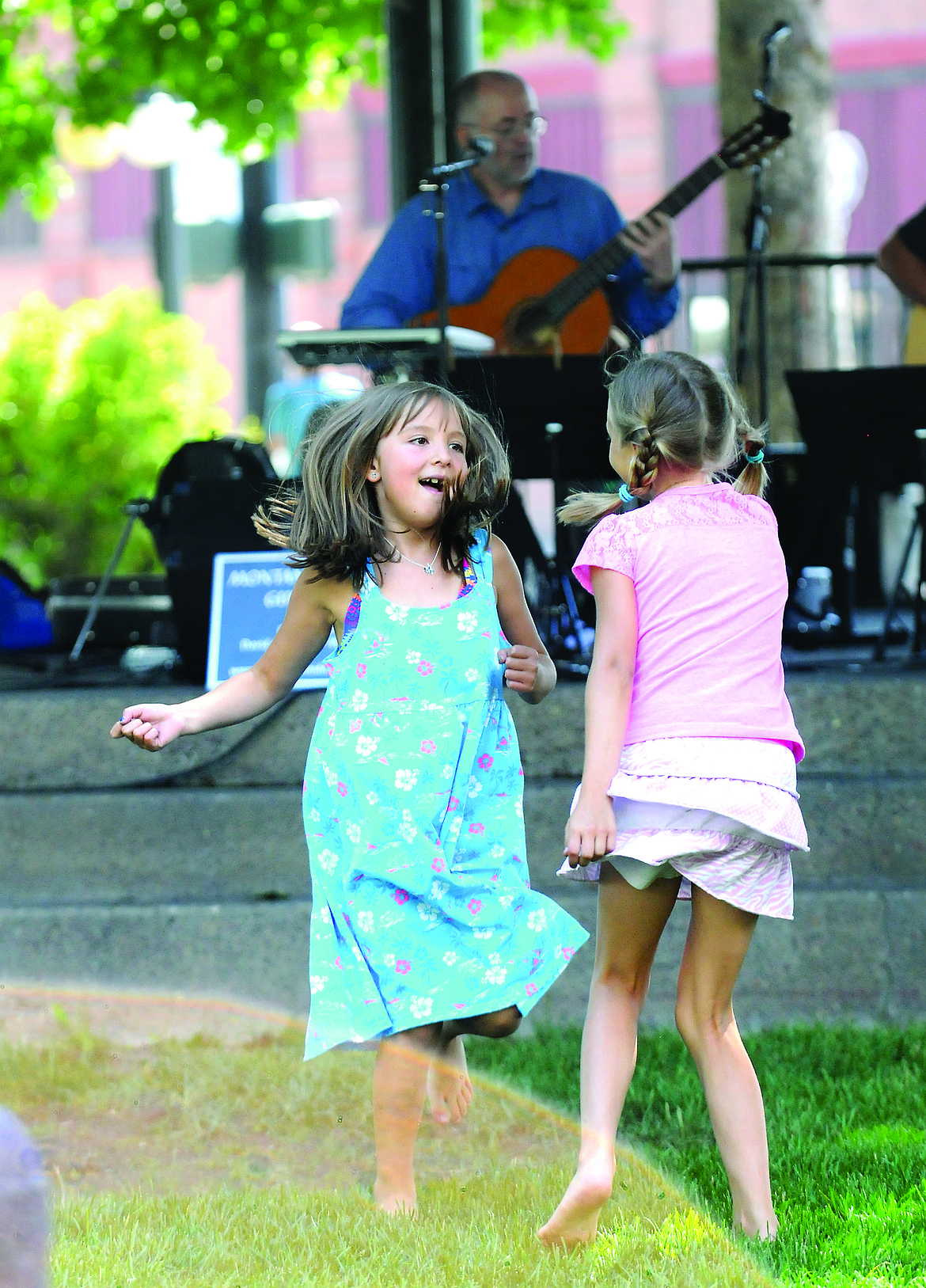 MAHRIAS SCHULZE, left, and Samantha Schaming dance to the music of the Montana Midnight Guitar Trio during Picnic in the Park at Depot Park. (Aaric Bryan/Daily Inter Lake, file)