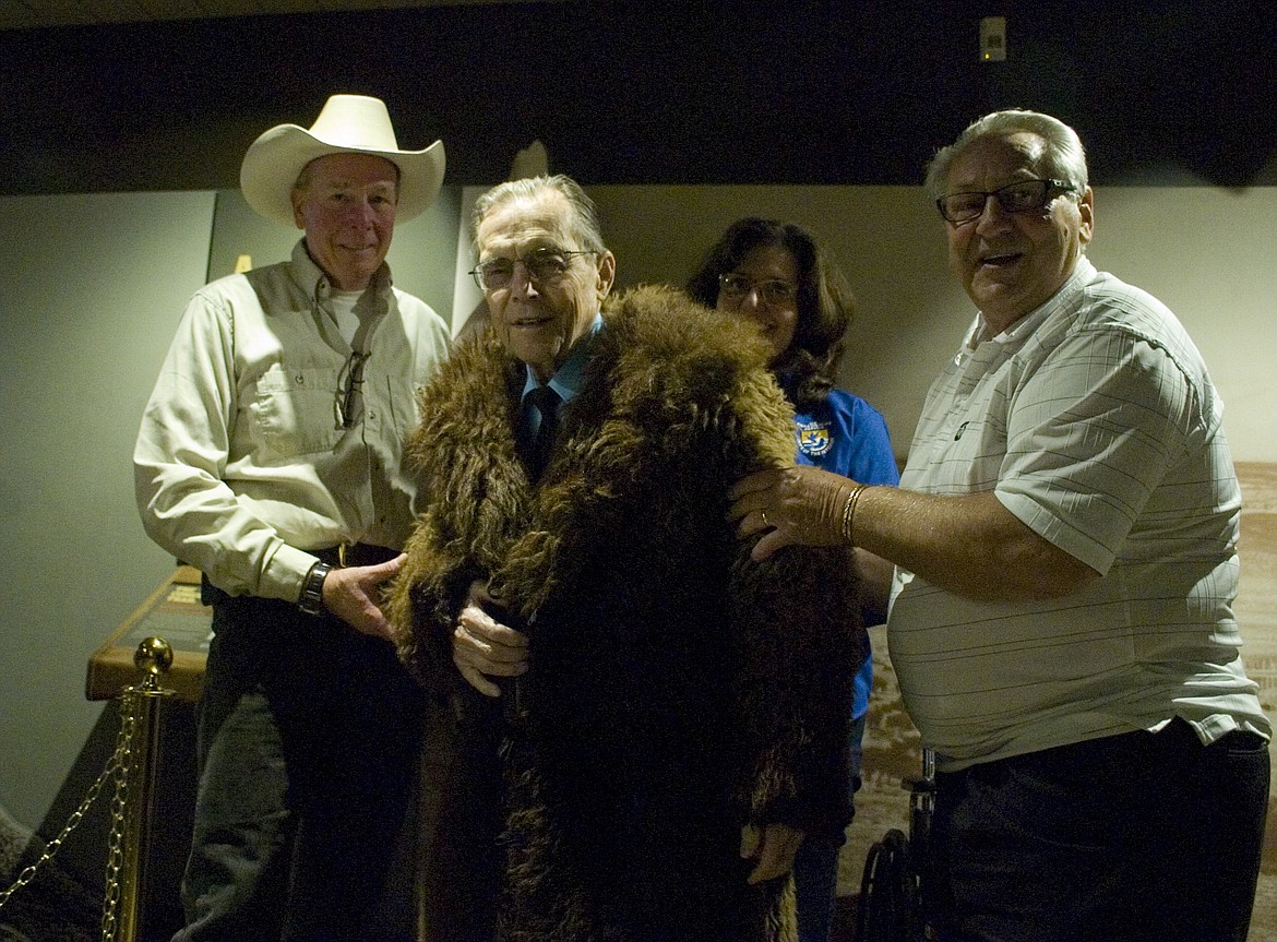 Courtney Gimbel, center, wears the buffalo fur coat he donated to the National Bison Range with help from Jeff King, left, and Harold Kindopp, right. (Brett Berntsen/Lake County Leader)