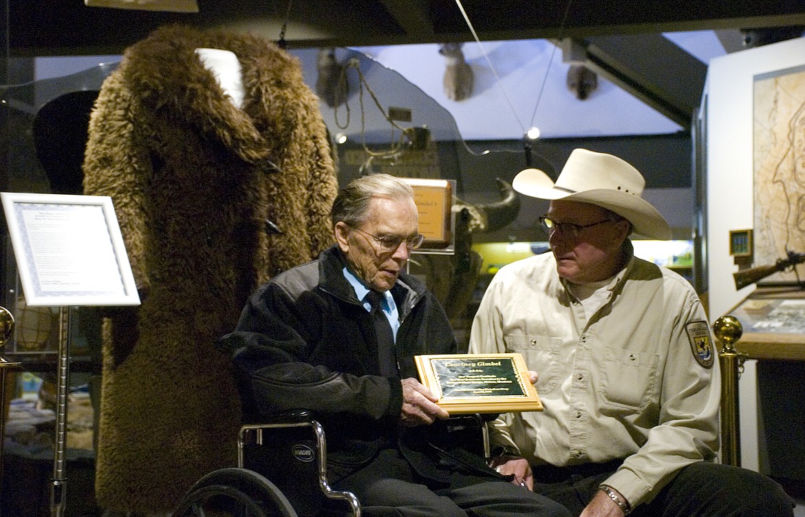 National Bison Range Project Manager Jeff King, right, presented Courtney Gimbel with a plaque last week commemorating Gimbel&#146;s donation of the antique buffalo fur coat displayed behind them. (Brett Berntsen/Lake County Leader)