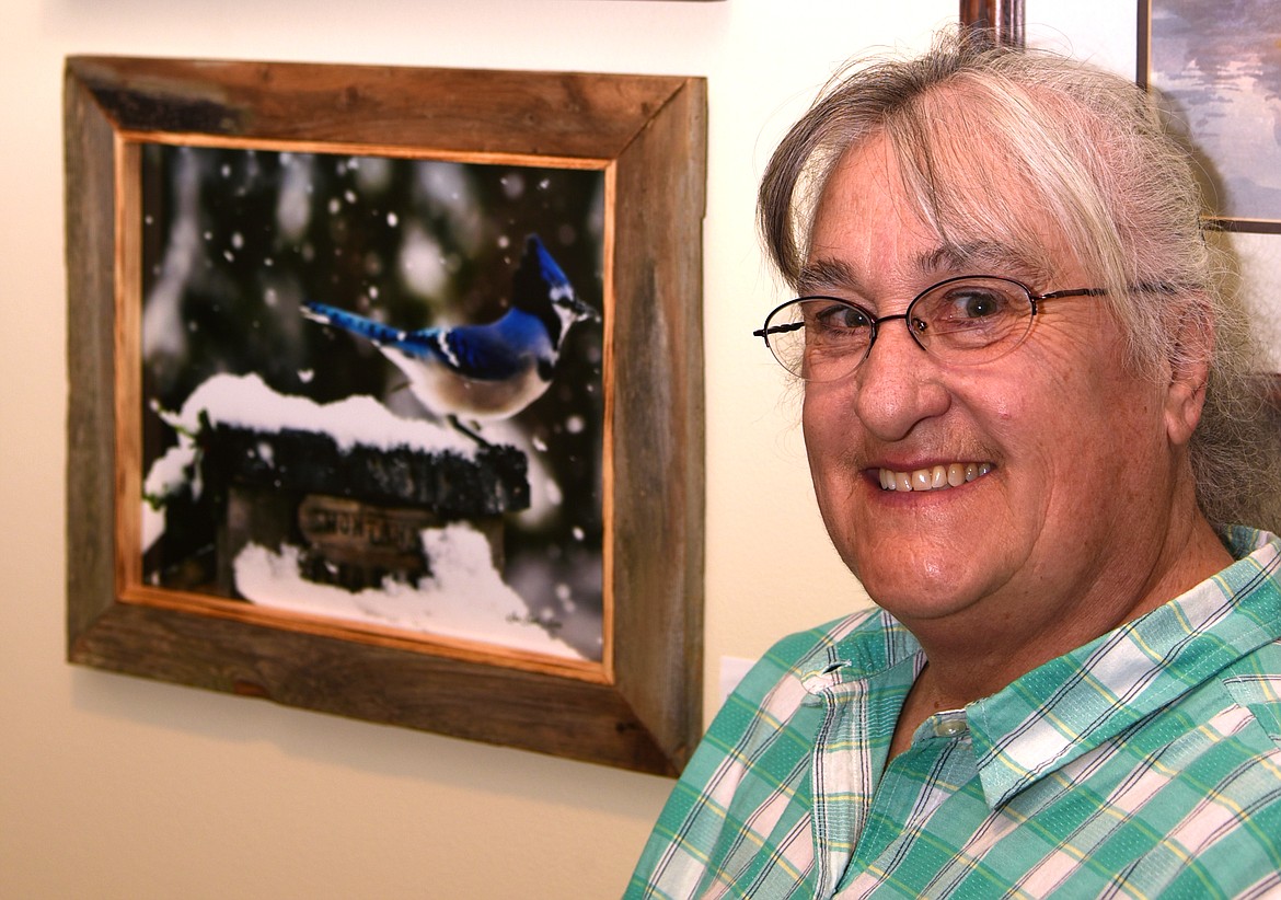 Sue Honts Mann poses next to her photograph at the opening of the summer art show at the Clark Fork Valley Hospital. Organized by the Sanders County Arts Council, a portion of the proceeds from art sales from the show benefit the hospital. (Marla Hall/Clark Fork Valley Press)