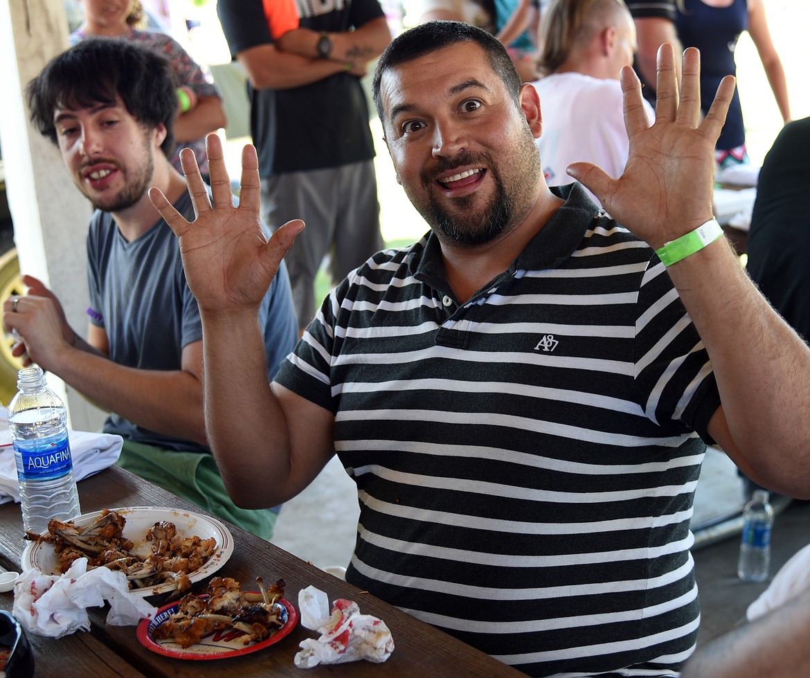 Matt Jaramillo raises his hands in triumph as the winner of the Wings Eating Contest. (Marla Hall/Clark Fork Valley Press)