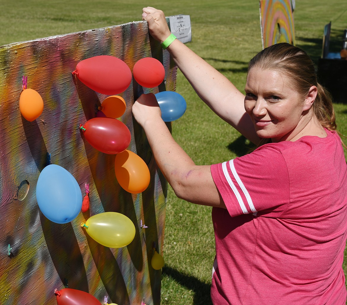 Shondelll Brown adds balloons to one of the games that she and her husband, Jason, built for the summer kick-off.