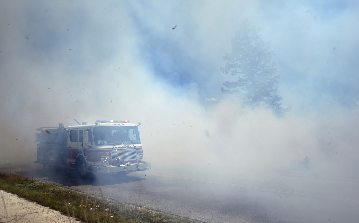 The Kalispell Fire Department arrives at the scene of a grassfire on Appleway Drive on Wednesday afternoon, June 21. Adam Smart said that driving up to the fire they had almost zero visibility.(Brenda Ahearn/Daily Inter Lake)