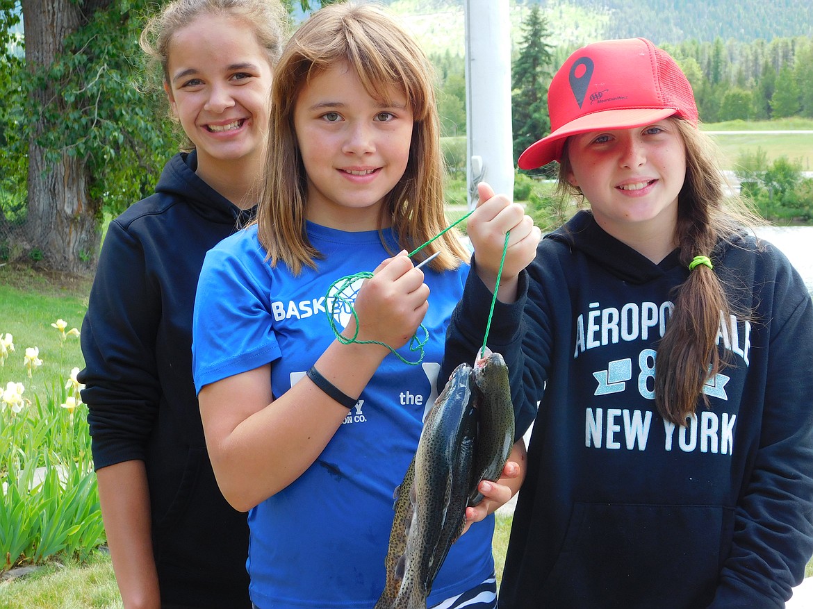 Superior Sisters Akasha and Trina Azure and Ki Woolley are all smiles with a stringer of fish caught in Savenac Pond. (Photo by Robert Webb).