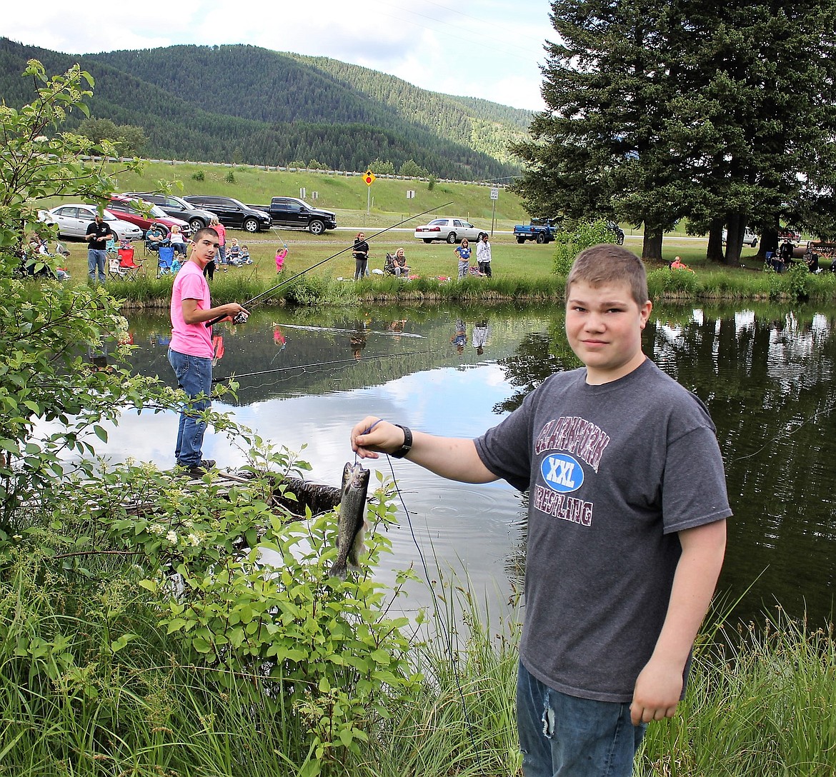 CHARLES ANDERSON, 12, holds up trout he and his brother Thomas caught in Savenac Pond.