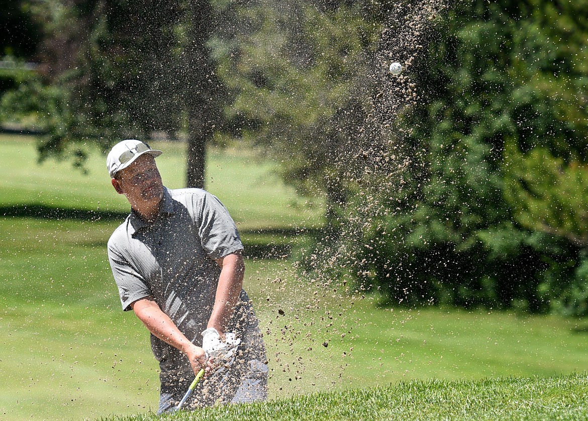 Logan Lindholm hits his ball out of the bunker on the 15th hole of the Whitefish Lake Golf Club&#146;s North Course during the 4th of July Tournament on Friday. (Aaric Bryan/Daily Inter Lake)