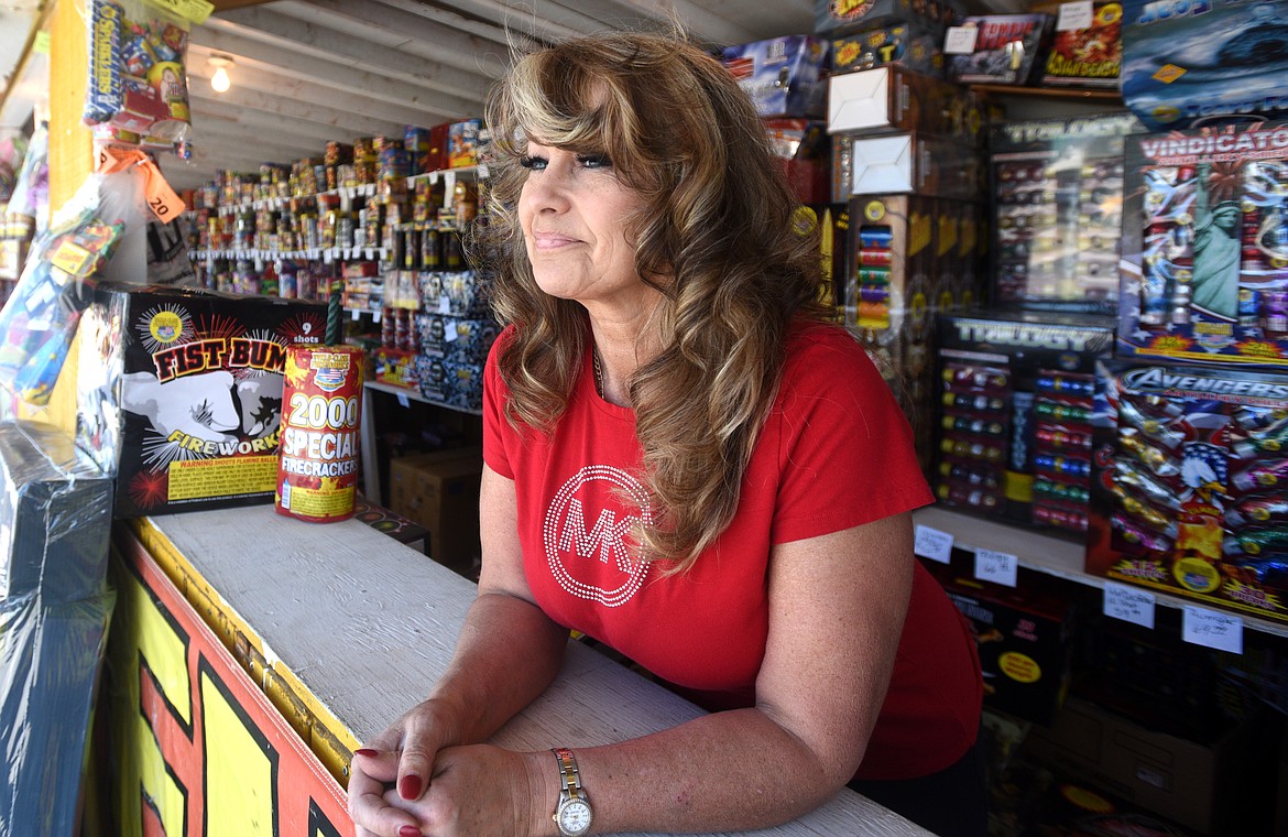 Wandy Robinson waits for customers at the Robinson Fireworks stand in Evergreen on Friday.