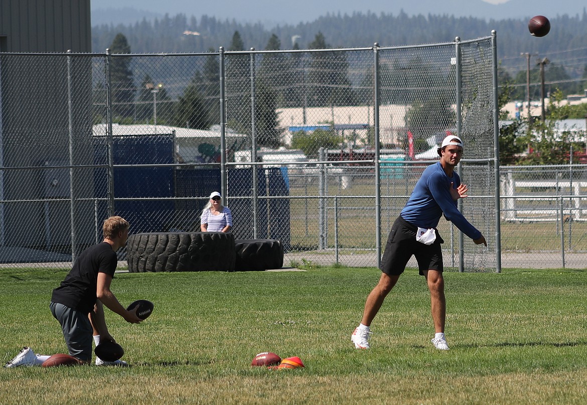 ERIC PLUMMER/Bonner County Daily Bee
Brock Osweiler throws as pass as Coeur d'Alene High senior quarterback Colson Yankoff, left, readies to toss him the next ball Friday at Coeur d'Alene High.