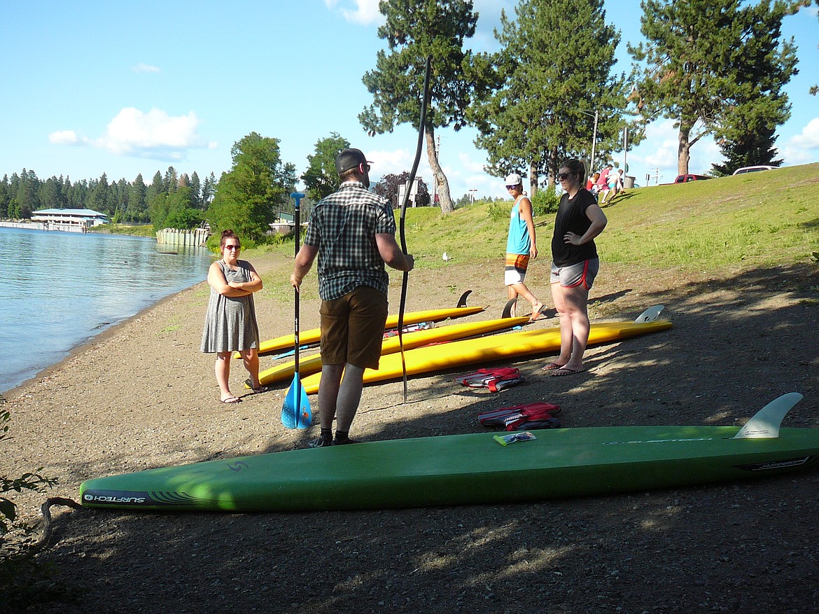 JERRY HITCHCOCK/Press
Chris Celentano (holding paddles) discusses proper use of paddles during a standup paddleboard lesson through Kayak Coeur d&#146;Alene. Students Danielle Costa (left) and Emily Boyd (right) listen with Kayak Coeur d&#146;Alene employee Jack Judge in the background.